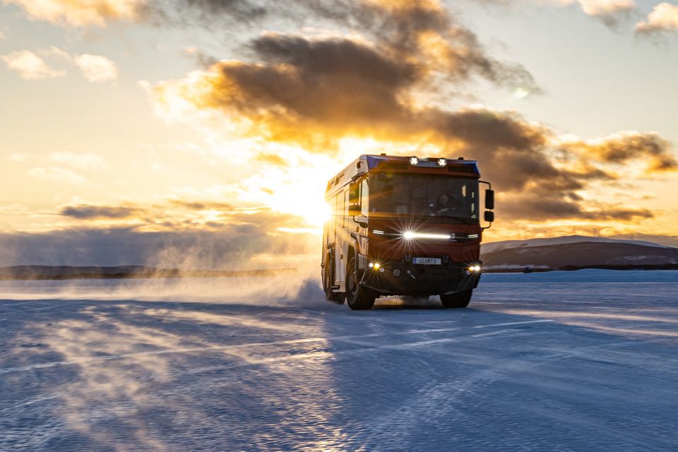 RT: Dynamically staged on a snow-covered roadway against the light The RT from an angled front view on a snow-covered surface at dusk against the light.