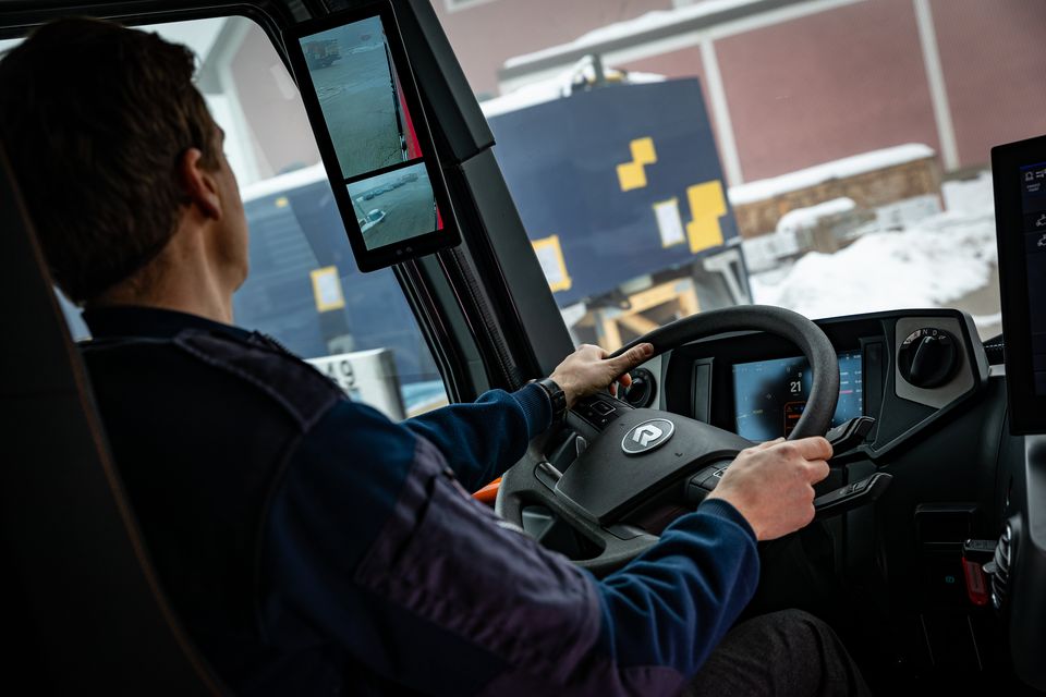 RT: Driver from behind with view of outside camera display View of the driver from the crew compartment. The display of the exterior cameras is in focus.