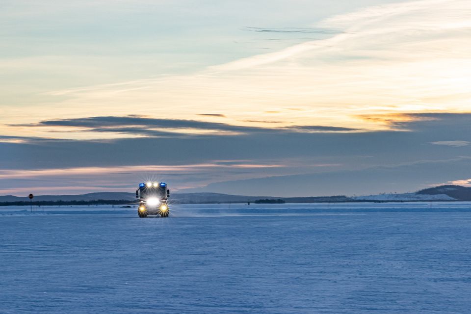 RT: Winterliche Landschaft RT in der Ferne Frontansicht des RT mit voller Beleuchtung in einer verschneiten Umgebung bei Dämmerung.